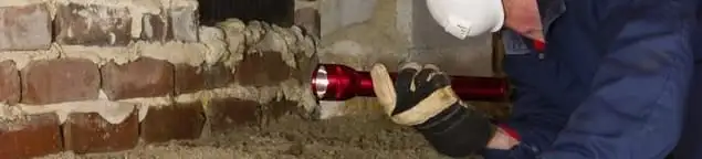 Pest control technician inspecting a crawl space for ant activity and entry points in Green Bay, WI